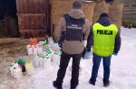 Funkcjonariusz KAS i policjant stoją przy pojemnikach z pestycydami