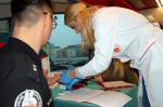 Pracownicy i funkcjonariusze w ambulansie podczas akcji krwiodawstwa