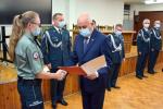 Funkcjonariuszka odbiera akt mianowania od Dyrektora Izby Administracji Skarbowej w Białymstoku, w tle kierownictwo podlaskiej KAS
