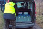 Funkcjonariusz KAS ładuje butelki do auta