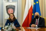 Za stołem Minister Finansów, Szef Krajowej Administracji Skarbowej. W tle flagi Polski i Unii Europejskiej