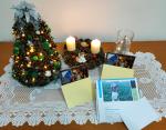Na stoliku mała choinka z szyszek, kartki świąteczne i kartka z informacjami o zbiórce charytatywnej.