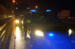 Tir i radiowóz stoją na poboczu drogi w nocy