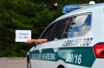 Radiowóz Służby Celno-Skarbowej, kierowca wystawia rękę, w ręku trzyma kartkę z napisem dołącz do nas.