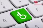 klawiatura laptopa, na jednym klawiszu zielony znak osoby niepełnosprawnej na wózku inwalidzkim
