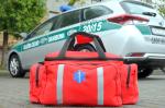 samochód służby celno skarbowej i torba ratownika do udzielania pierwszej pomocy