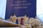 eksponaty muzealne na stole, w tle baner krajowa administracja skarbowa