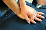 Reanimacja - ręce kobiety na klatce piersiowej leżącej osoby