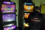 Funkcjonariusz KAS w lokalu na tle dwóch automatów do gier hazardowych
