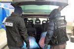 Funkcjonariusze KAS i SG przy otwartym bagażniku forda, w którym widać worki z tytoniem