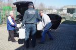 Funkcjonariusz Służby Celno-Skarbowej i przedstawiciele Wojewódzkiej Stacji Sanitarno-Epidemiologicznej umieszczają przekazywany alkohol w pojeździe