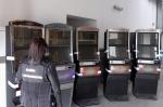 Funkcjonariuszka KAS stoi przy 5 automatach do gier hazardowych