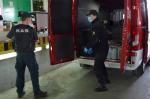 Funkcjonariusz KAS i strażak ładują skrzynki z alkoholem do busa