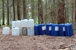 Plastikowe pojemniki stojące w lesie